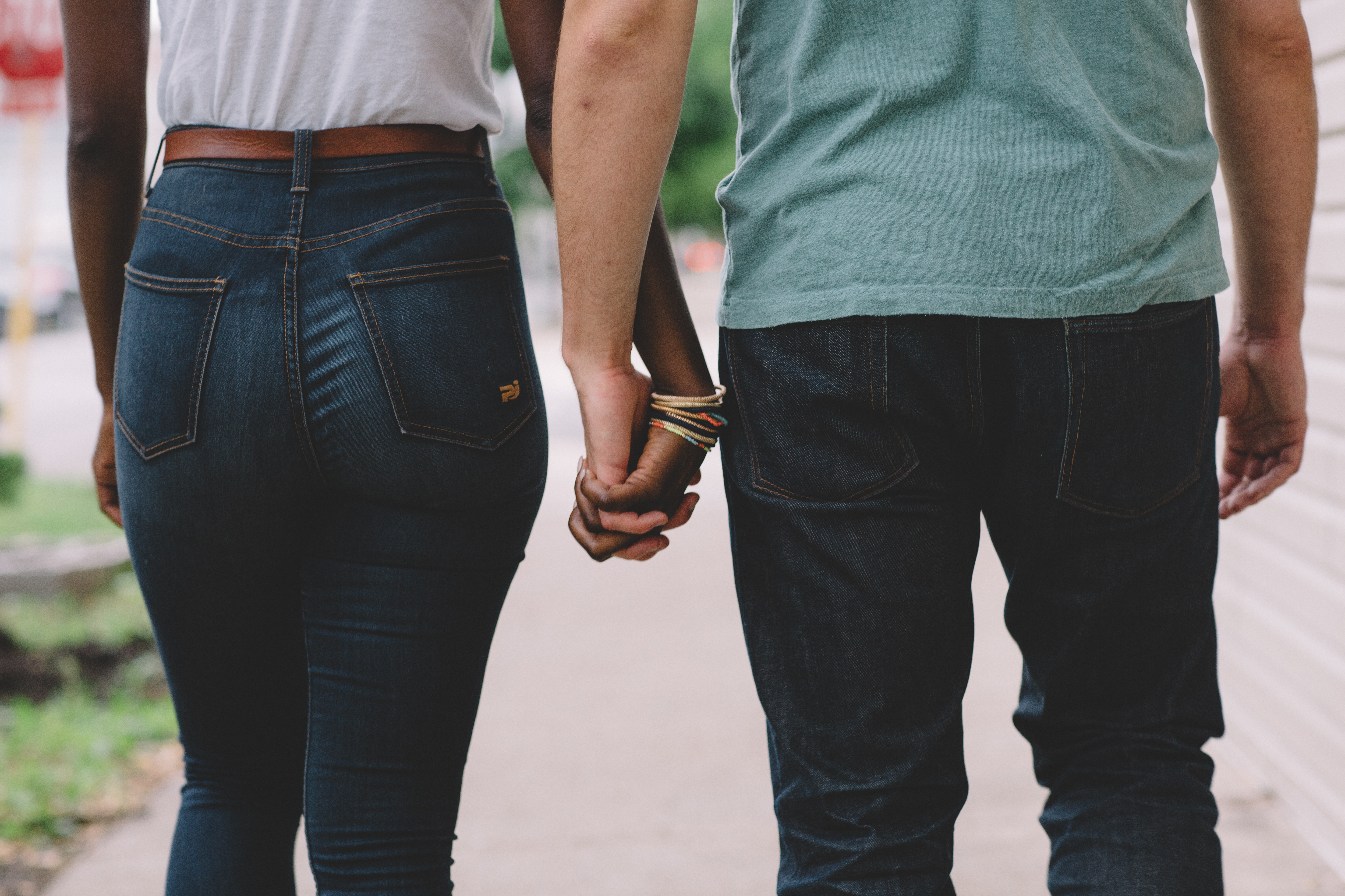 couple shown from the waist down holding hands and walking