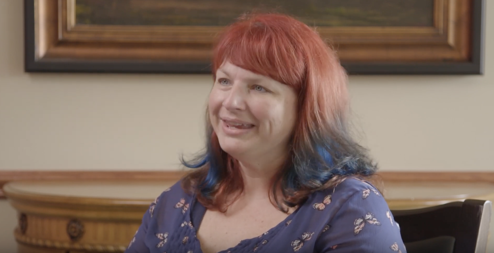 white woman with red and blue hair being interviewed