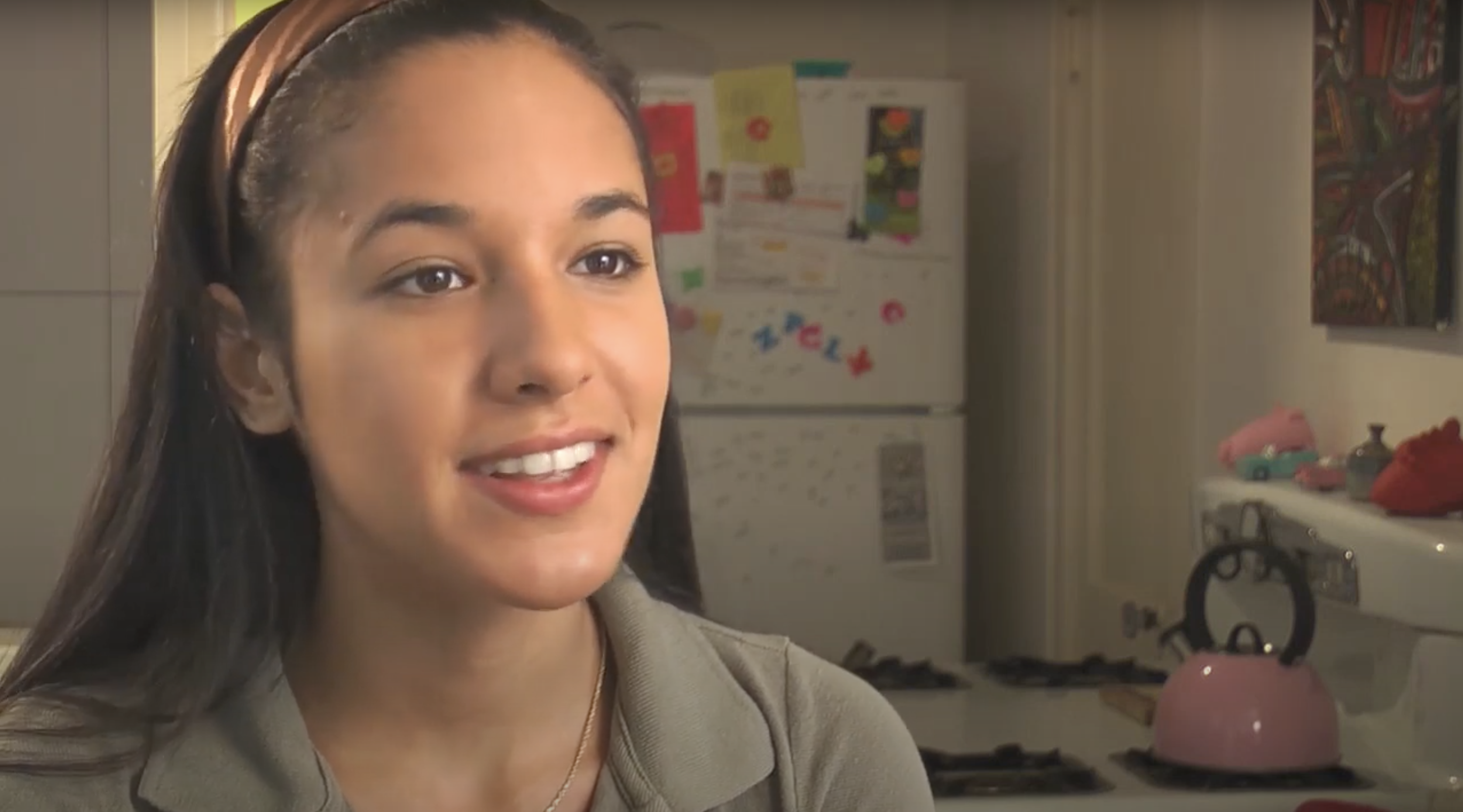 woman with brown hair and a gray shirt talking about her birth control