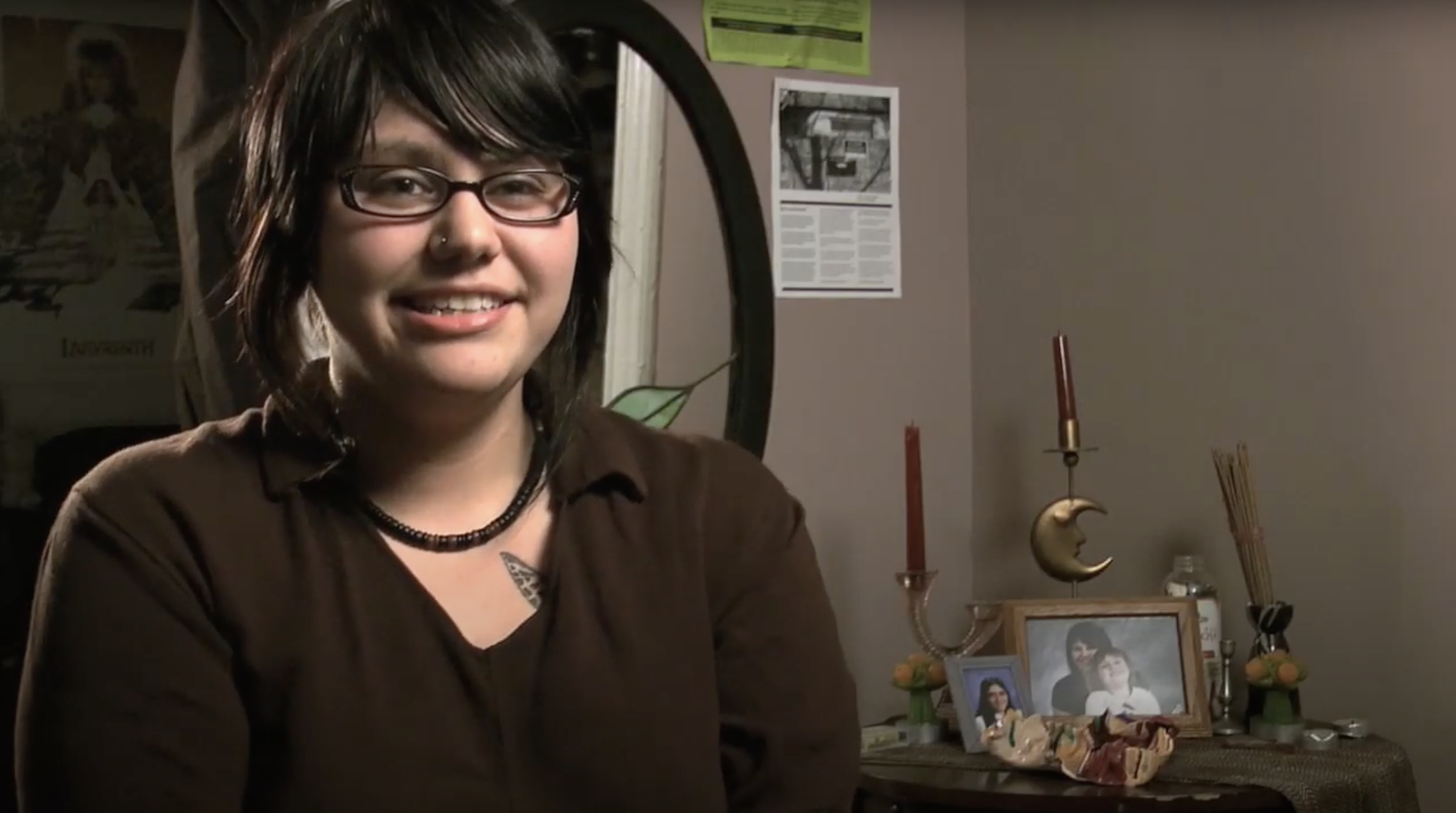 woman with dark hair and glasses and a brown shirt talking about her birth control