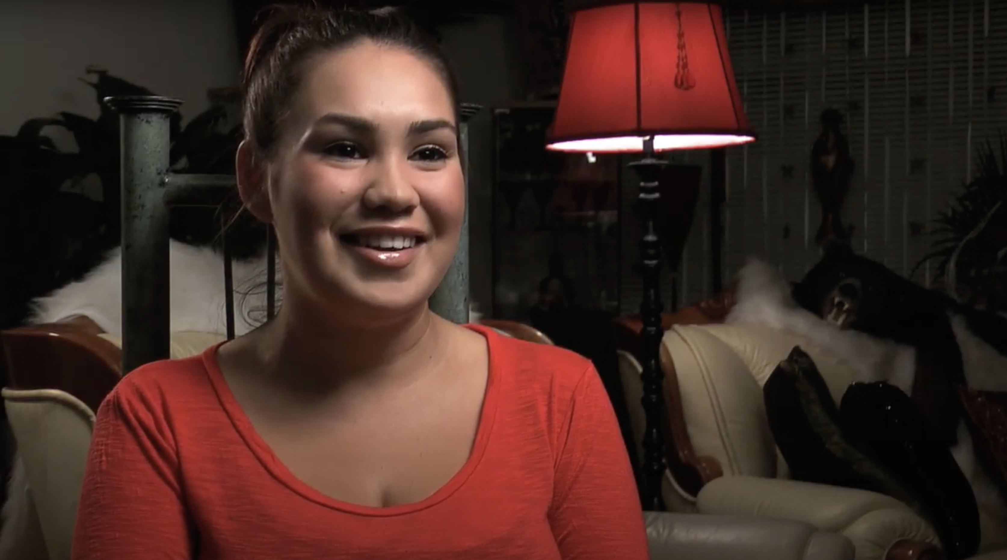 woman with dark hair and a red shirt talking about her birth control