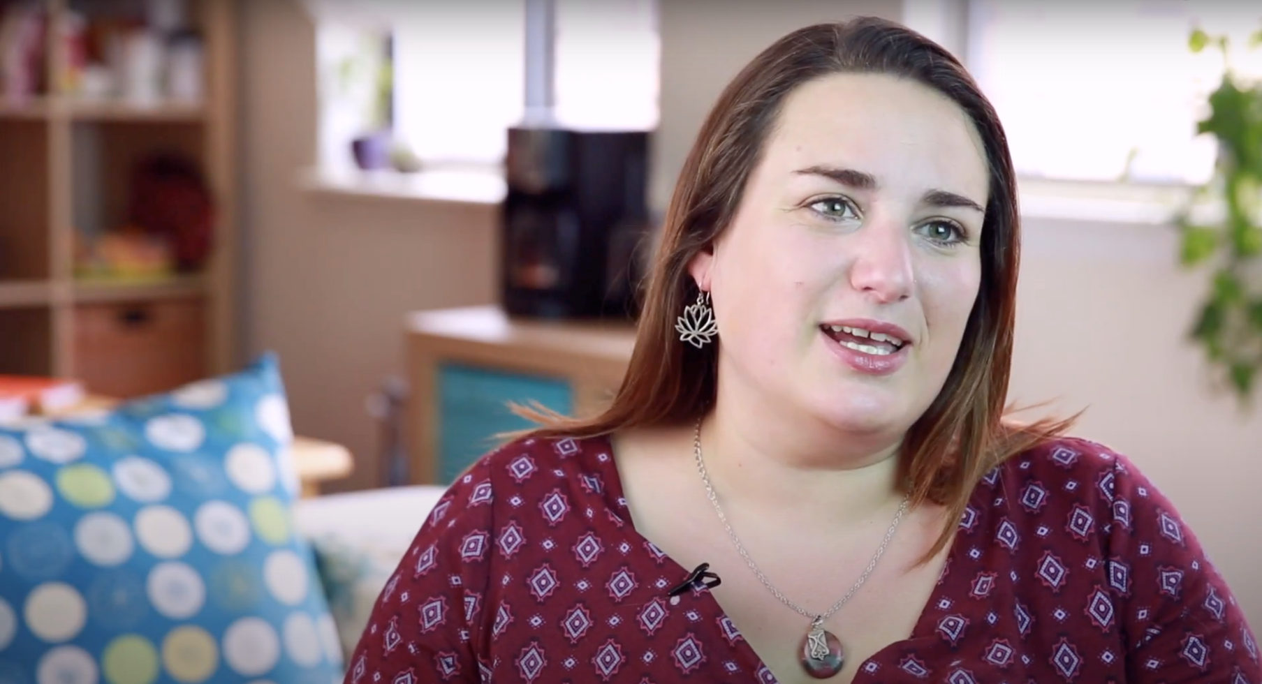 woman with shoulder length brown hair and burgundy shirt talking about her birth control to camera