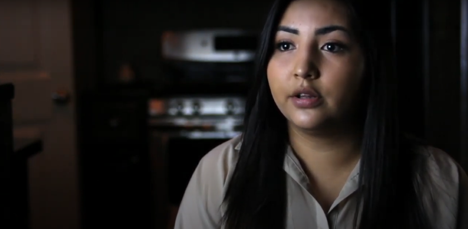 BIPOC woman with long dark hair and a light shirt talking about her method of birth control to camera