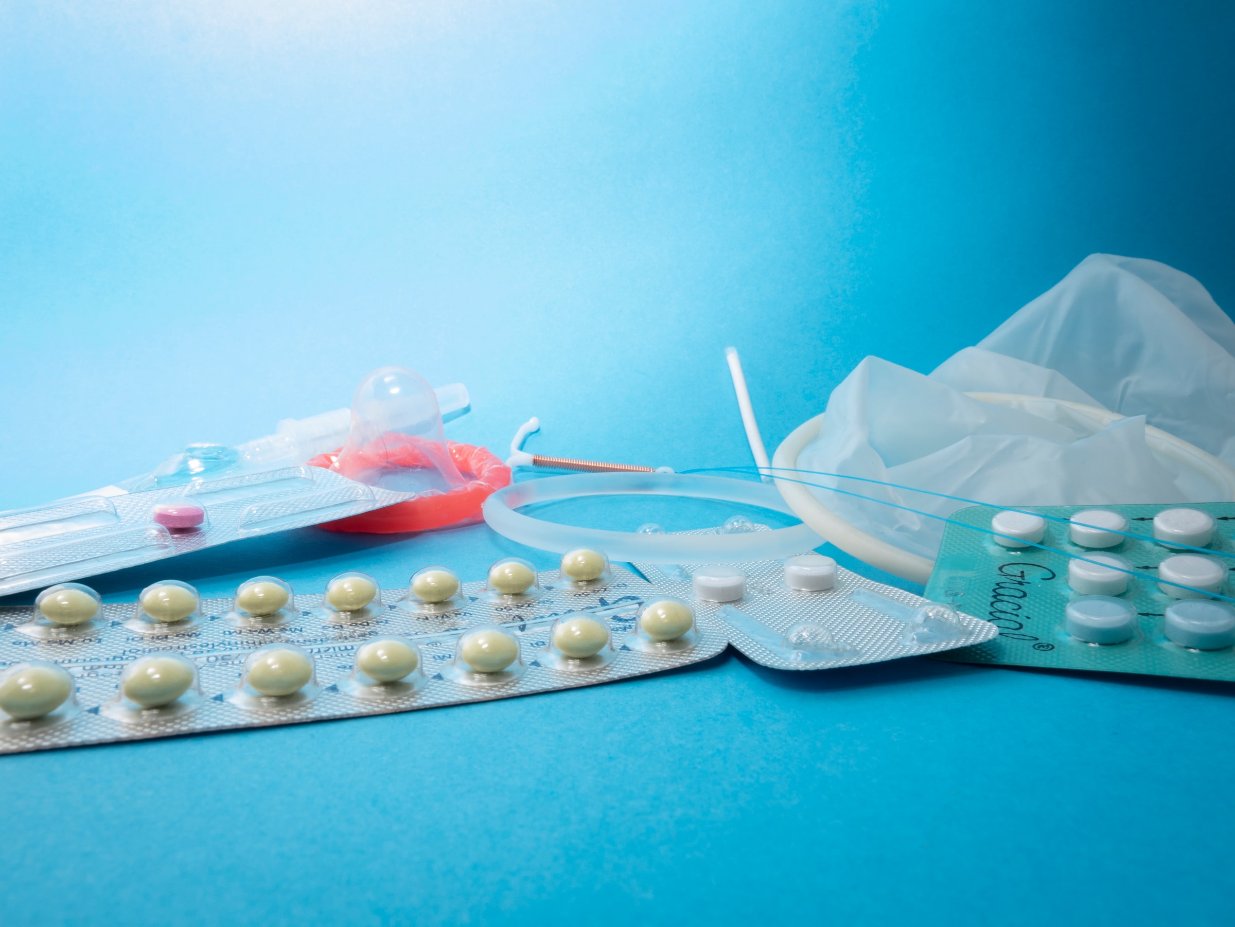 several birth control methods laid out on a blue background