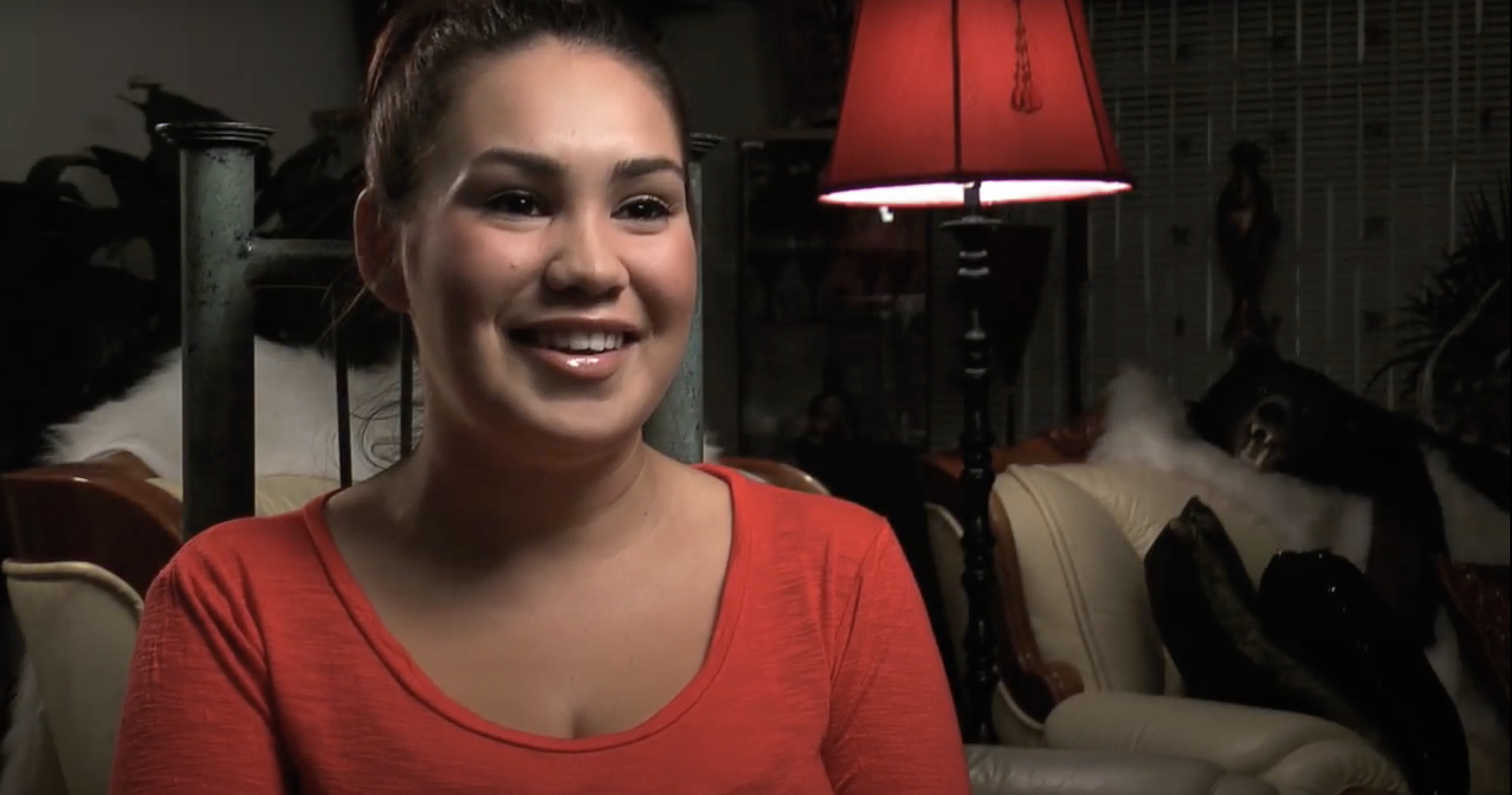 woman with dark hair and a red shirt talking about her birth control