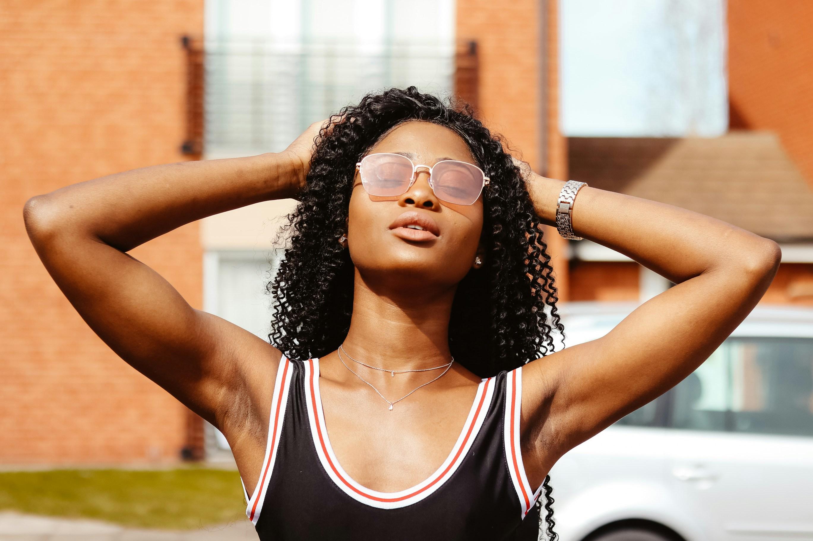 female POC with glasses and dark hair looking up at the sky, relaxed