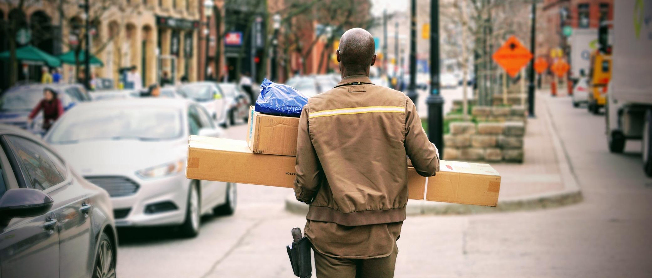 Man delivering boxes to a destination.