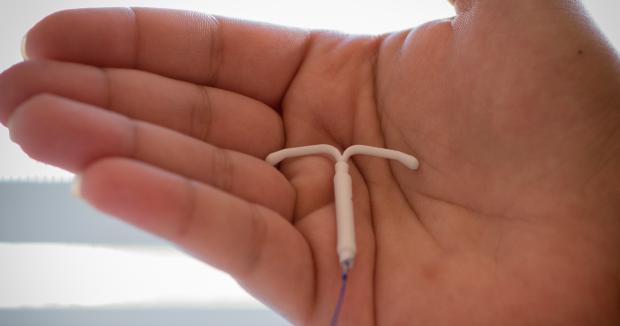closeup of an IUD in the palm of a person's hand