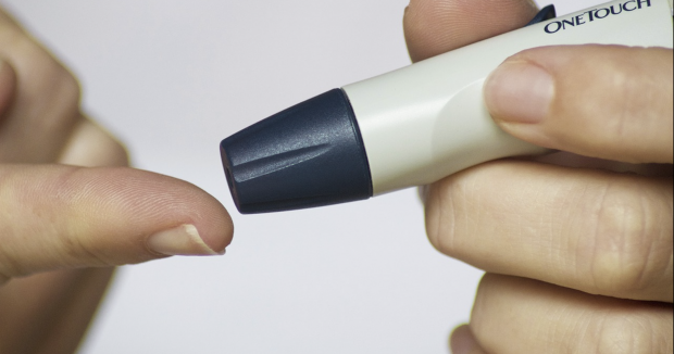 a person about to test their blood sugar with a diabetes testing device