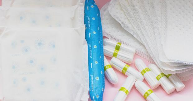 various menstrual products displayed on a pink background