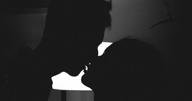 couple kissing in a dark room